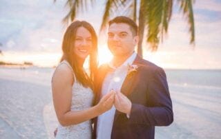 A Key West wedding at sunset, with a bride and groom standing on the beach.