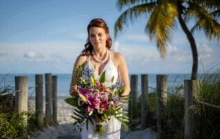 A bride holding a bouquet on a wooden walkway during her Key West wedding.
