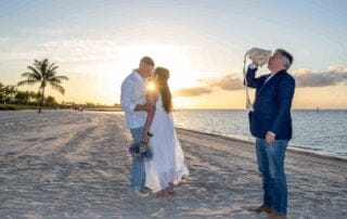 A stunning bride and groom kissing on the beach at sunset during their unforgettable Key West wedding.