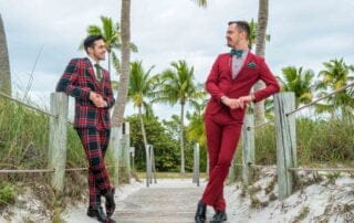 Two men in plaid suits standing on a wooden boardwalk for their Key West wedding ceremony.