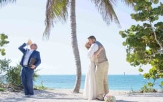 A romantic bride and groom sharing a passionate kiss during their Key West beach wedding.