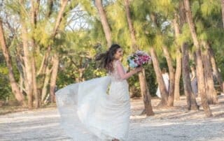 A bride in a wedding dress running through the trees at her Key West wedding.