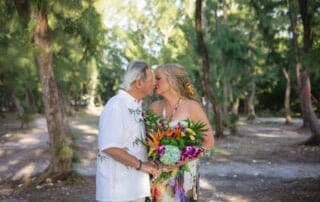 A bride and groom sharing an intimate kiss during their woodland wedding captured by a talented Key West wedding photographer.
