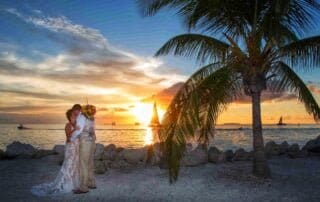 A beautiful bride and groom capturing their special moment on the beach at sunset, with the assistance of a skilled key west wedding photographer.