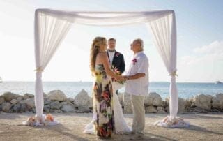 A bride and groom exchange vows on a beach in Key West.