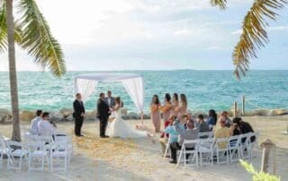 A beautiful beach wedding ceremony enhanced by palm trees, captured by a talented Key West wedding photographer.
