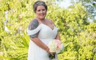 A bride in a white wedding dress holding a beautiful bouquet, captured by a talented Key West wedding photographer.