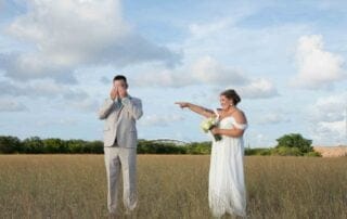 A beautiful bride and groom standing in a picturesque field, captured by a talented Key West wedding photographer.
