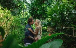 A couple embraces in a tropical garden, captured by a talented key west wedding photographer.
