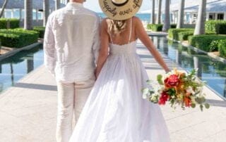A bride and groom walking down a walkway with palm trees in the background, captured beautifully by a Key West wedding photographer.
