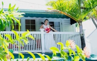 A bride standing on the balcony of a picturesque white house in Key West.