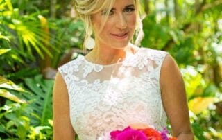 A bride in a white dress holding a bouquet of colorful flowers during her Key West wedding.