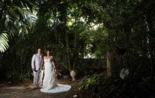 A bride and groom celebrating their key west wedding in a tropical garden, surrounded by lush foliage and vibrant flowers.