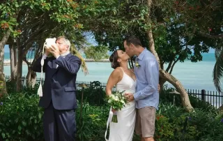 A bride and groom sharing a passionate kiss in front of a beautiful maze at their Key West wedding.