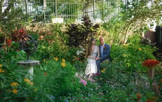 A bride and groom posing in a garden, captured beautifully by key west wedding photographers.