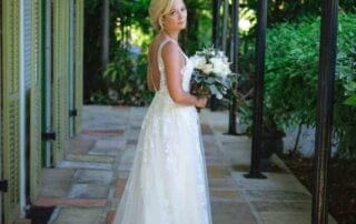 A beautiful bride in a stunning wedding dress standing in a picturesque courtyard captured by a talented Key West wedding photographer.