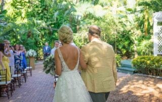 A bride walks down the aisle at her Key West wedding with her father.