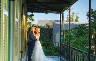 A bride and groom share a beautiful kiss on a balcony in New Orleans, captured by a talented Key West wedding photographer.