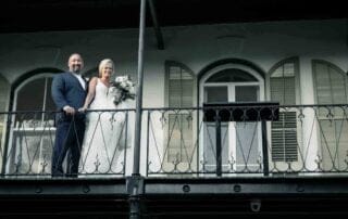 A bride and groom enjoying the romantic view from the balcony of a building during their Key West wedding ceremony.