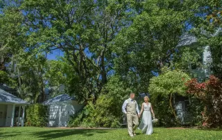 A bride and groom walking in front of a house, captured by a talented Key West wedding photographer.