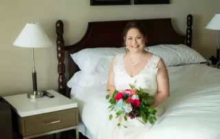 A bride sitting on a bed in a hotel room, preparing for her Key West wedding.