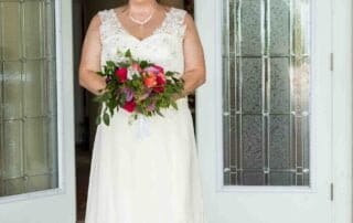 A bride in a wedding dress standing in front of a door, captured by a talented Key West wedding photographer.
