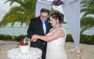 A bride and groom cutting their beach wedding cake in Key West.