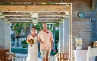 A bride and groom elegantly walking down the aisle at a resort in Key West, surrounded by the enchanting ambiance curated by expert Key West wedding planners.