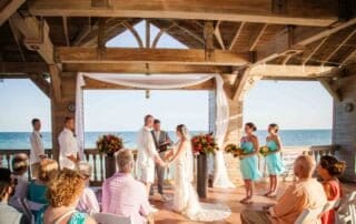 A bride and groom exchange vows under a beautiful gazebo on the beach with the assistance of a key west wedding officiant.