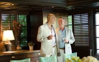 Two men standing next to each other in a dining room, captured by a skilled Key West wedding photographer.