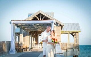 A bride and groom capture their special day with a memorable photo session on a picturesque pier, surrounded by the breathtaking beauty of the ocean. The talented key west wedding photographer perfectly frames the couple's