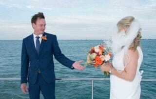 A bride and groom exchange vows on the deck of a boat during their Key West wedding ceremony.