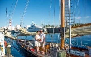 A man and woman standing on the bow of a sailboat during their Key West wedding ceremony.