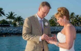 A bride and groom exchange rings on a dock during their Key West wedding.