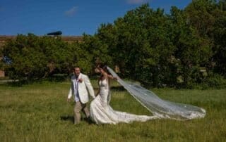A bride and groom walking through a grassy field during their Key West wedding ceremony.