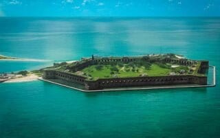 An aerial view of an island in the middle of the ocean, showcasing its picturesque beauty and remoteness.