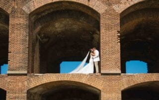 A bride and groom sharing a romantic kiss in the coliseum, captured by the skilled lens of key west wedding photographers.