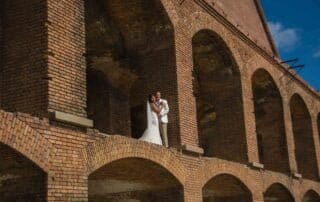 A bride and groom standing in front of an old brick building during their key west wedding.