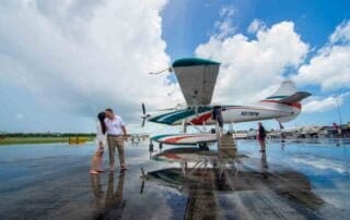 A couple standing next to a small plane on a wet tarmac for their Key West wedding, captured beautifully by a key west wedding photographer.