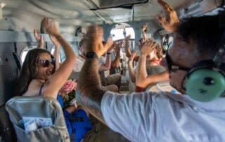 A group of people in a plane with their hands in the air, celebrating their unforgettable Key West wedding.