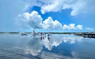 A group of people standing on a tarmac with planes in the background during a Key West wedding.