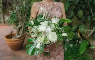 A woman in a dress holding a bouquet of white flowers captured by a Key West wedding photographer.