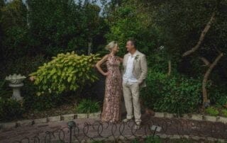 A bride and groom pose for a photo in a garden during their Key West wedding ceremony.