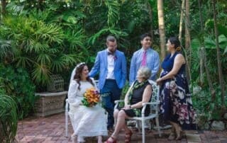 A group of people posing for a photo in a beautiful garden with a professional key west wedding photographer capturing their special moments.