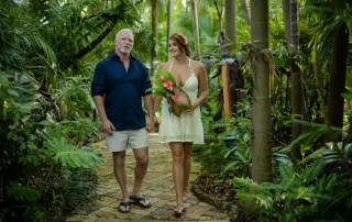 A man and woman walking through a tropical garden during their Key West wedding.