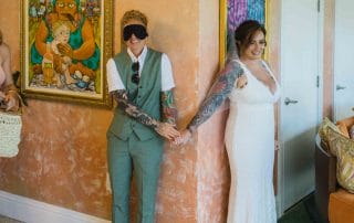 A bride and groom are holding hands in a room.