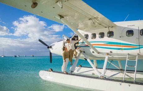Wedding Dry Tortugas Two people disembarking from a seaplane parked on clear blue tropical water near Key West, with boats and skies visible in the background.